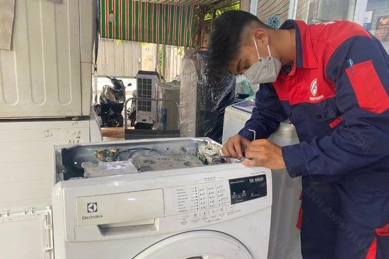 Kỹ thuật viên Điện Lạnh Đức Tín đang kiểm tra và sửa máy giặt tại nhà khách hàng ở quận Hà Đông, Hà Nội.