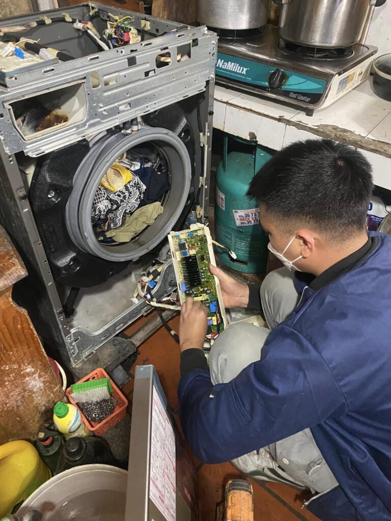 Thợ Điện Lạnh Đức Tín đang tháo lồng máy giặt cửa ngang để vệ sinh và thay linh kiện tại Hà Đông.